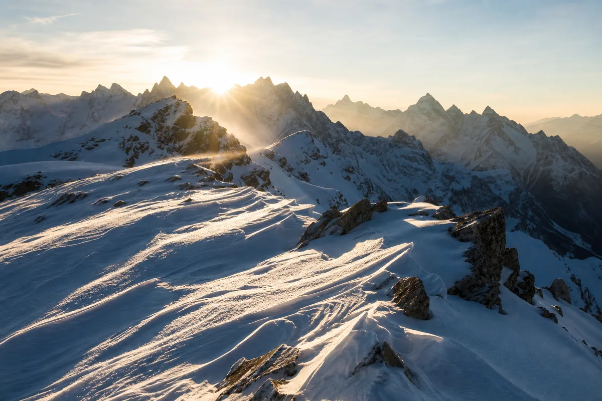 Sommet enneigé à contre-jour, lumière rasante et ombres marquées sur la neige